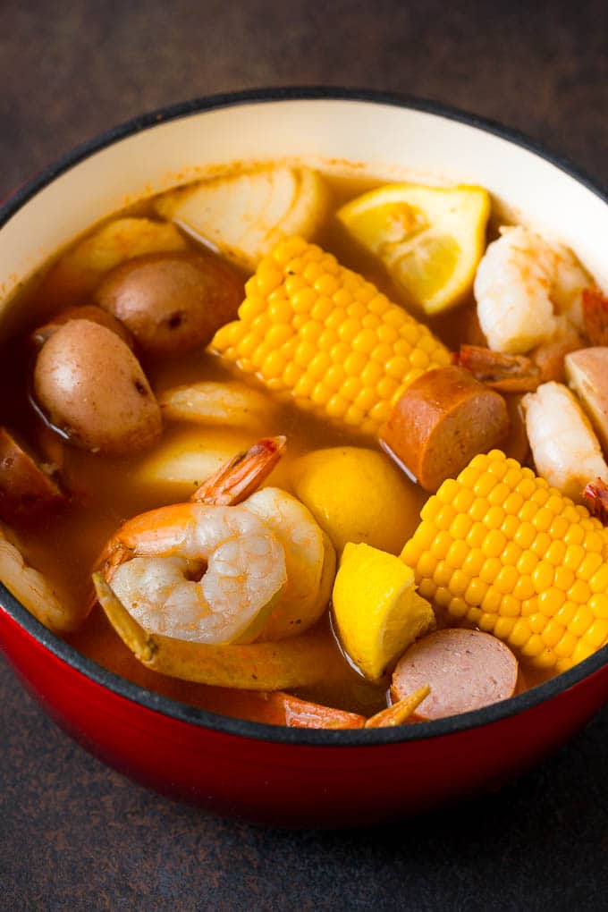 A pot of Low Country Boil with shrimp, corn on the cob, red potatoes, sausage and lemon